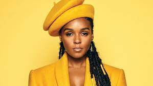 janelle monae posing in a yellow outfit with a yellow background